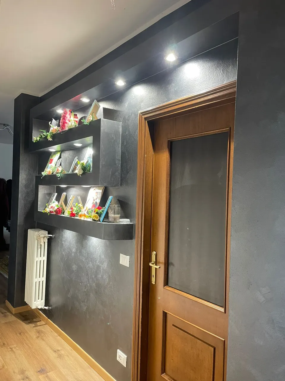 Nișe decorative cu spoturi LED aprinse, pe perete finisat în gri închis