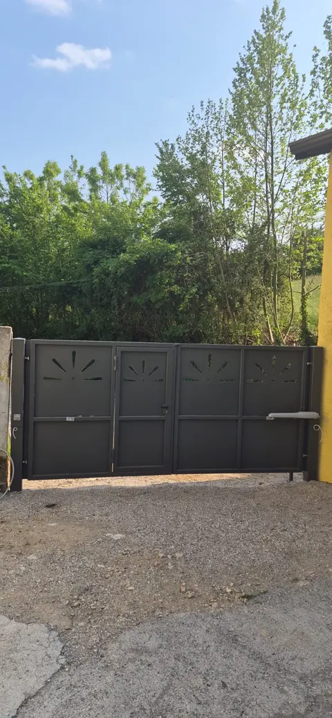 Poartă batantă închisă, cu motoare cu braț montate pe canaturi