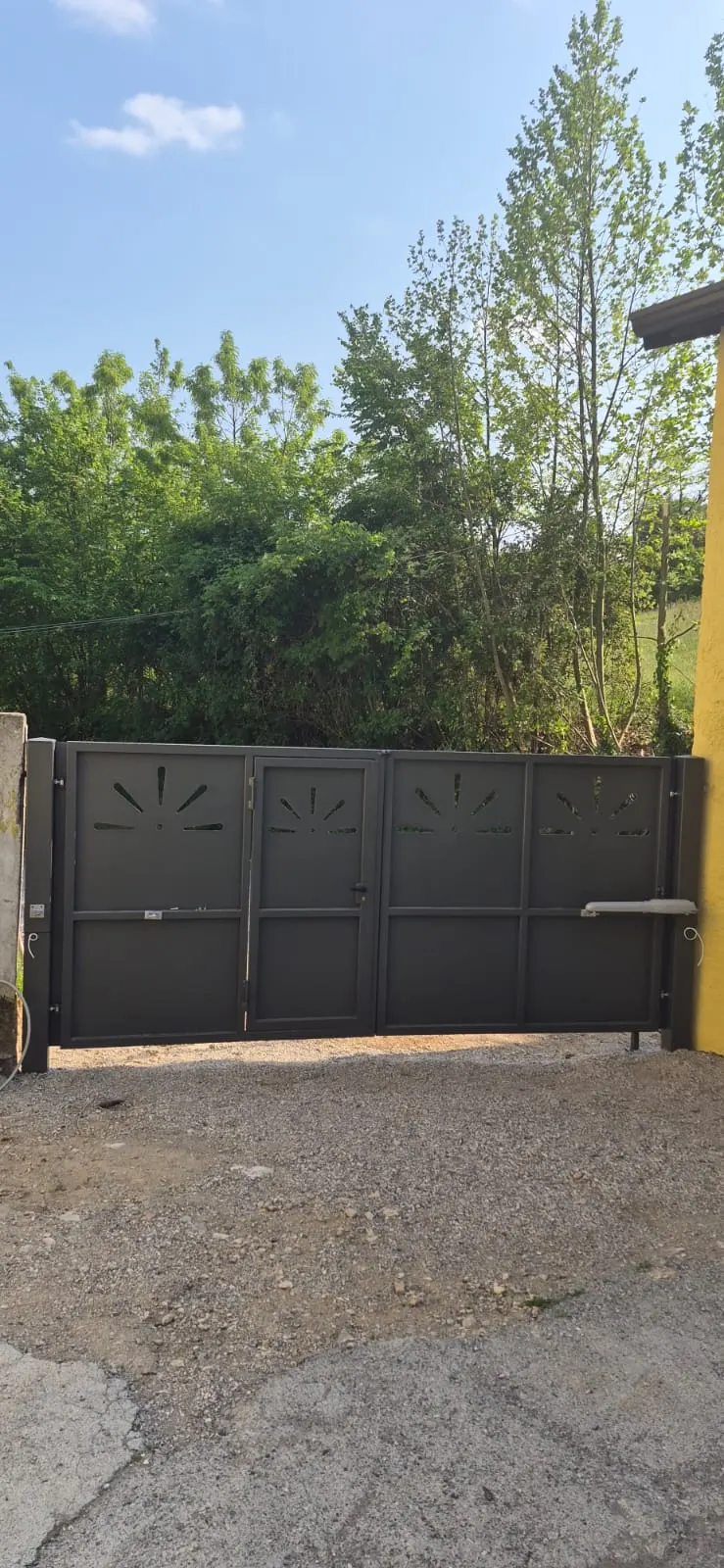 Poartă batantă închisă, cu motoare cu braț montate pe canaturi
